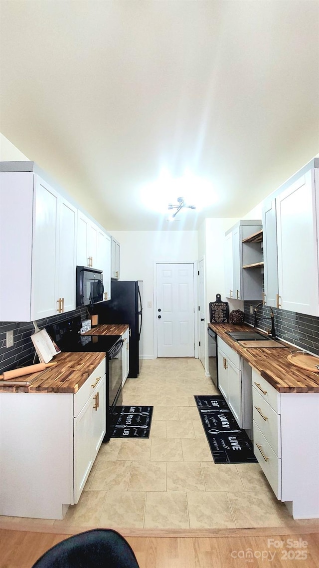 kitchen with black appliances, white cabinets, and wooden counters