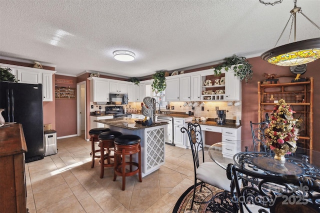 kitchen featuring tasteful backsplash, white cabinetry, crown molding, and black appliances