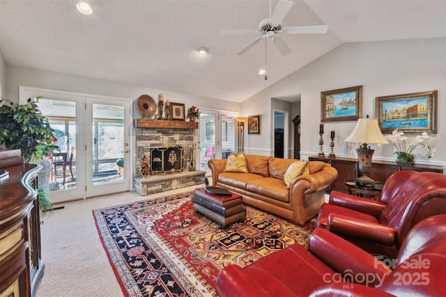 carpeted living room with a fireplace, ceiling fan, and lofted ceiling