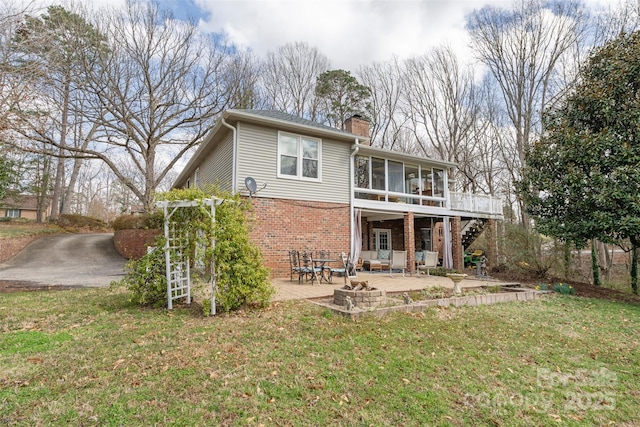 124 Muirfield Dr, Kings Mountain, NC 28086 - rear view of property featuring brick siding, a sunroom, a patio area, a chimney, and an outdoor fire pit