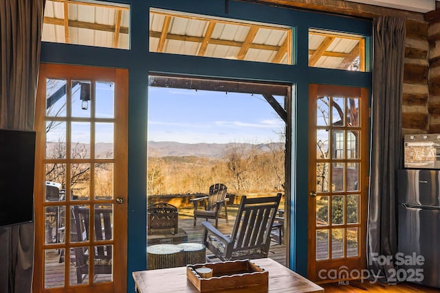 doorway with hardwood / wood-style flooring, a healthy amount of sunlight, and a mountain view