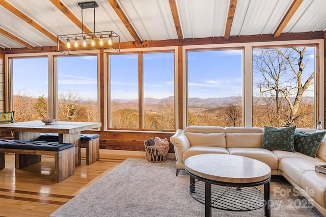 sunroom with beam ceiling and a mountain view