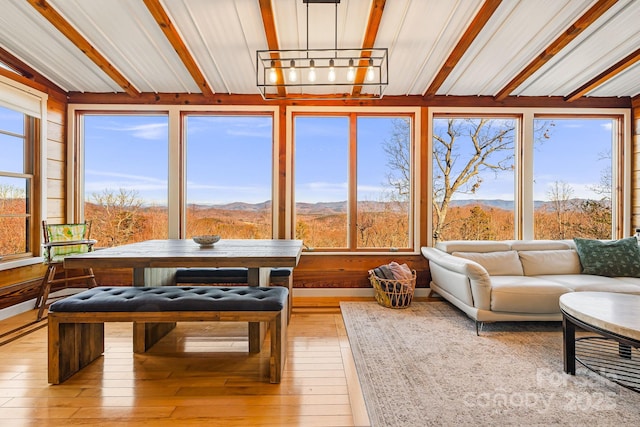 sunroom / solarium featuring lofted ceiling, a notable chandelier, and a mountain view