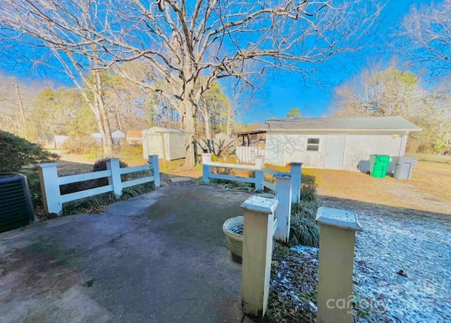 view of yard featuring central air condition unit and a storage unit