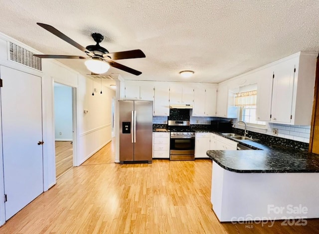 kitchen featuring white cabinetry, sink, tasteful backsplash, a textured ceiling, and appliances with stainless steel finishes