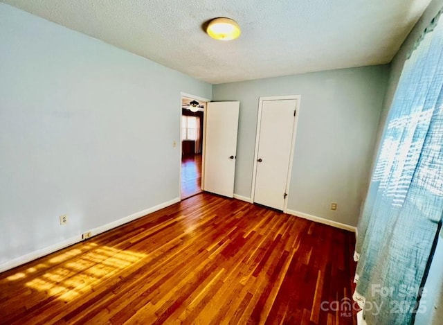 unfurnished bedroom with wood-type flooring and a textured ceiling