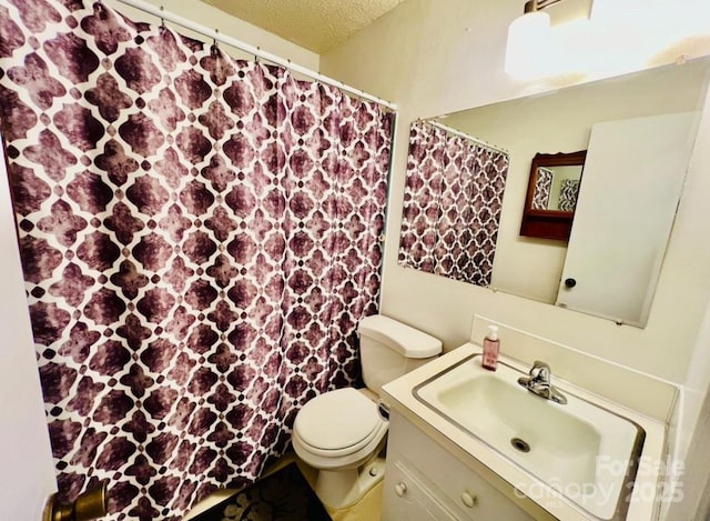 bathroom featuring vanity, a textured ceiling, and toilet