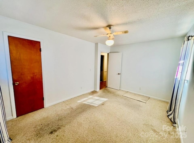 carpeted spare room featuring ceiling fan and a textured ceiling