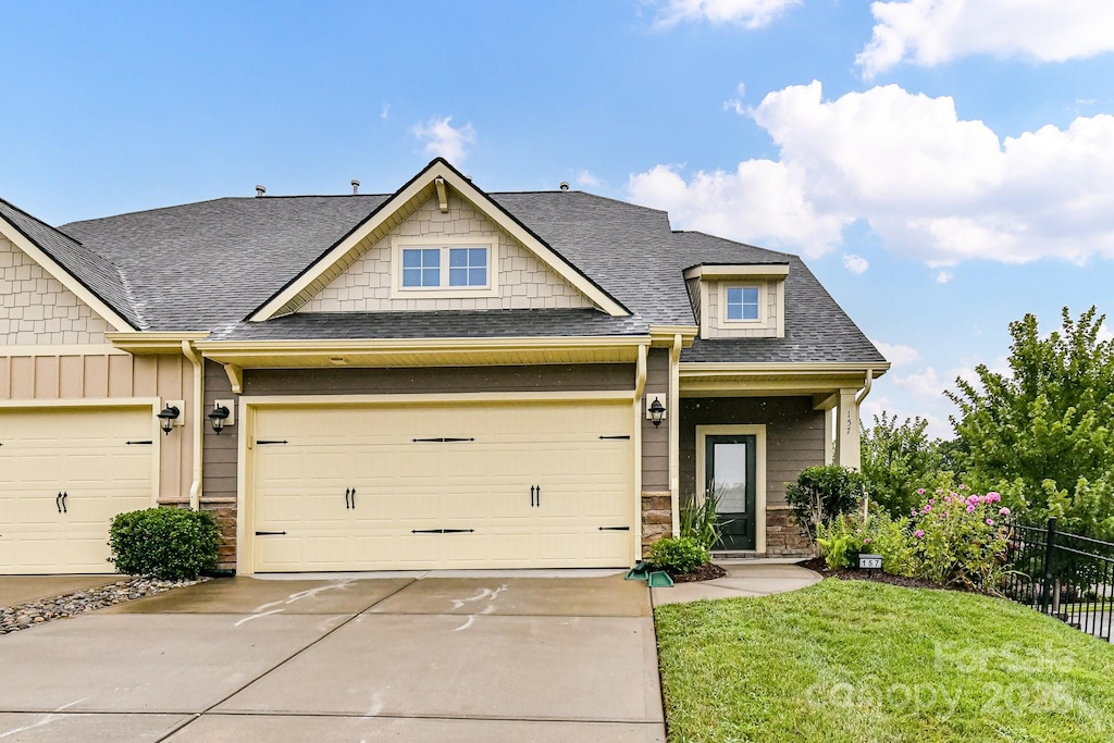 craftsman-style home featuring a front yard and a garage