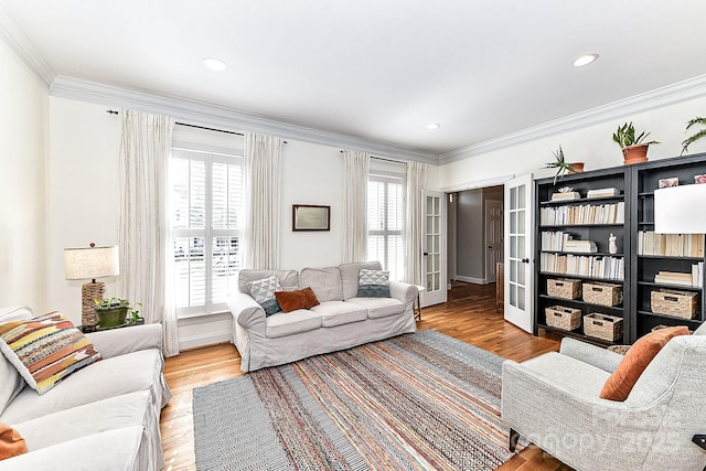 living room with french doors, ornamental molding, and light hardwood / wood-style floors