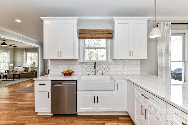 kitchen featuring hanging light fixtures, dishwasher, sink, and white cabinetry