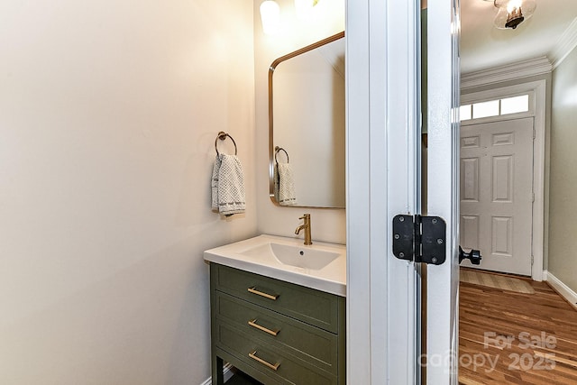 bathroom featuring vanity, crown molding, and wood-type flooring