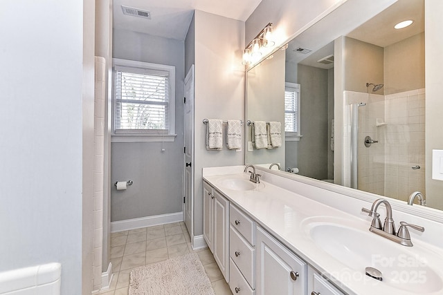 bathroom featuring tiled shower, vanity, and tile patterned flooring