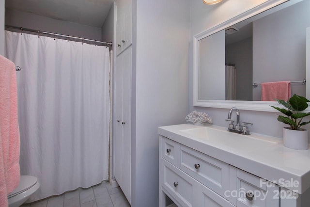 bathroom with tile patterned flooring, vanity, and toilet