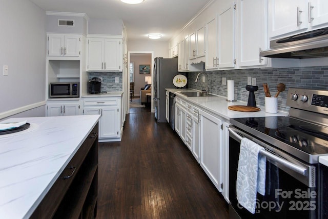 kitchen with sink, stainless steel appliances, white cabinets, and light stone countertops