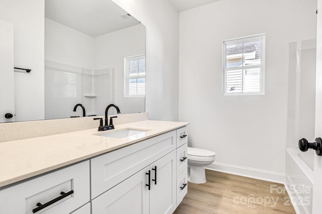 bathroom featuring hardwood / wood-style flooring, plenty of natural light, toilet, and vanity