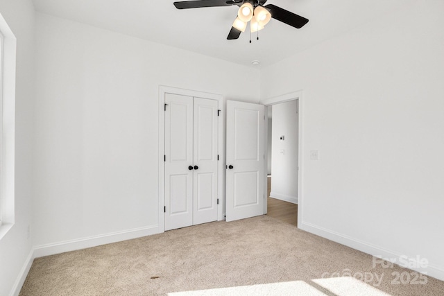 unfurnished bedroom with ceiling fan, a closet, and light colored carpet