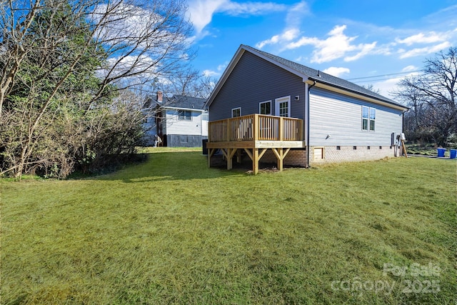 back of property with a deck and a lawn