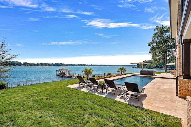 view of pool with a lawn, a patio area, and a water view