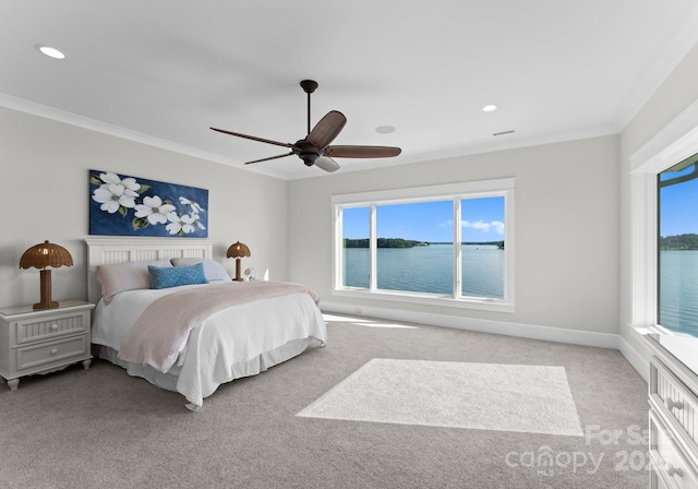 carpeted bedroom with multiple windows, a water view, ceiling fan, and ornamental molding