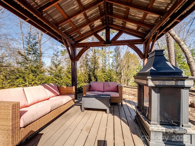 wooden terrace featuring an outdoor living space with a fireplace