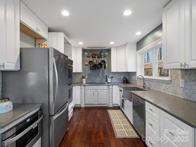 kitchen with stainless steel appliances, white cabinets, dark wood-type flooring, and tasteful backsplash