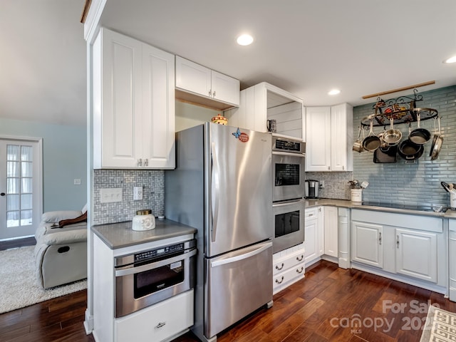 kitchen featuring recessed lighting, dark wood-style flooring, white cabinetry, appliances with stainless steel finishes, and backsplash