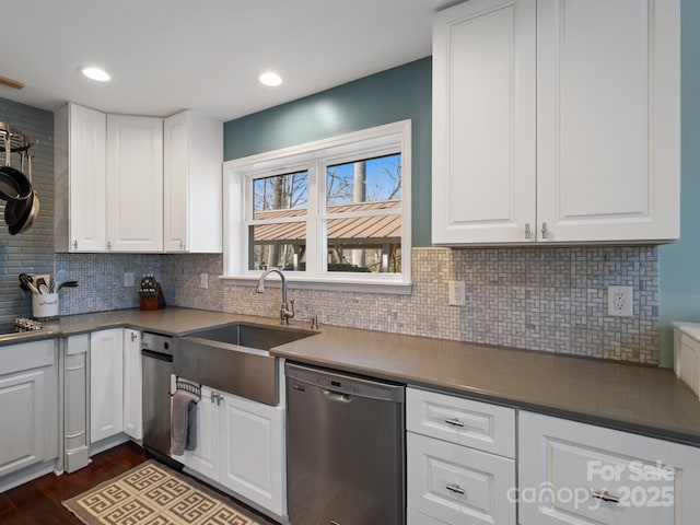 kitchen featuring sink, stainless steel appliances, white cabinets, dark hardwood / wood-style flooring, and decorative backsplash