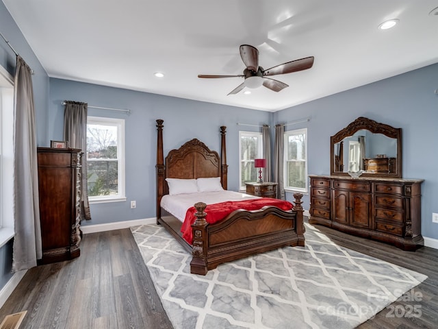 bedroom featuring ceiling fan, hardwood / wood-style floors, and multiple windows