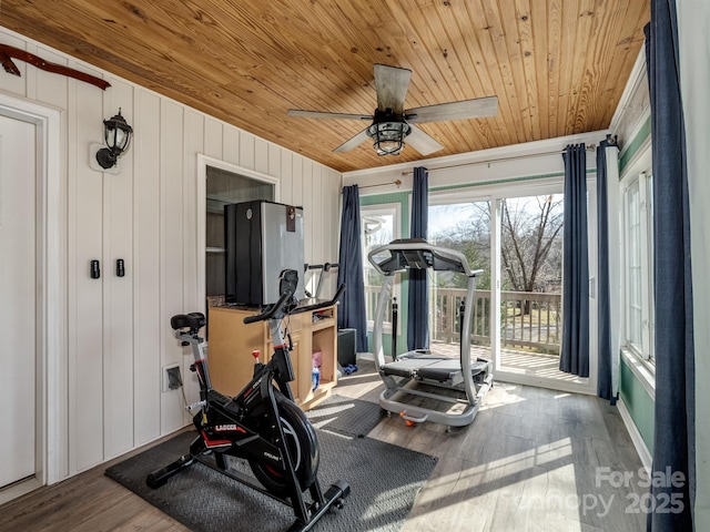 exercise area with wood finished floors, wood ceiling, and a ceiling fan