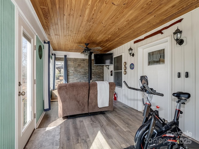 exercise room with ceiling fan, wood finished floors, and wood ceiling