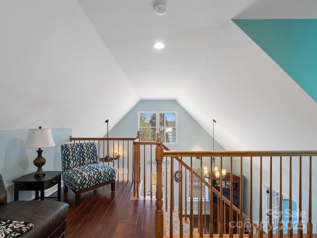 sitting room featuring wood-type flooring, vaulted ceiling, and a notable chandelier