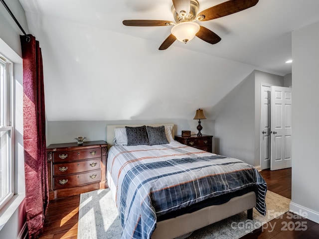 bedroom with lofted ceiling, ceiling fan, wood finished floors, and baseboards