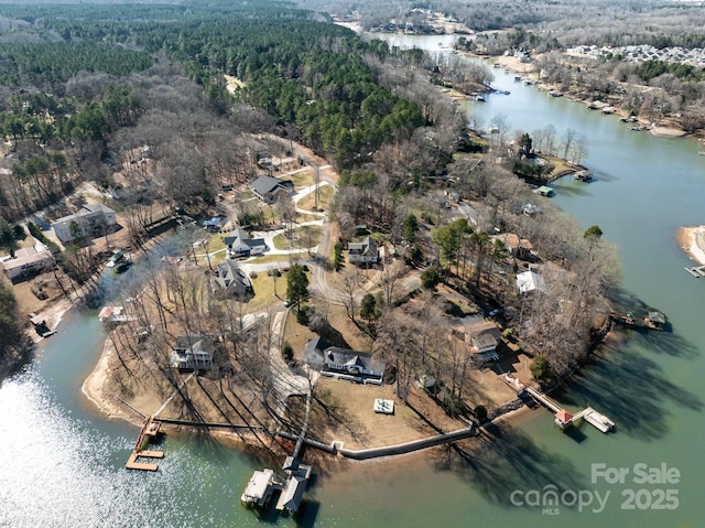 drone / aerial view with a forest view and a water view