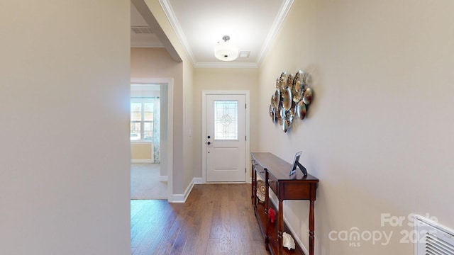 entryway with ornamental molding and hardwood / wood-style floors