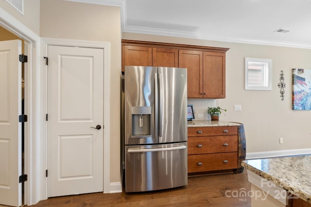 kitchen featuring stainless steel refrigerator with ice dispenser, backsplash, dark hardwood / wood-style floors, light stone counters, and crown molding