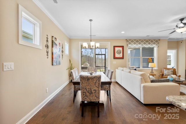 dining room with a wealth of natural light, crown molding, ceiling fan with notable chandelier, and dark hardwood / wood-style floors