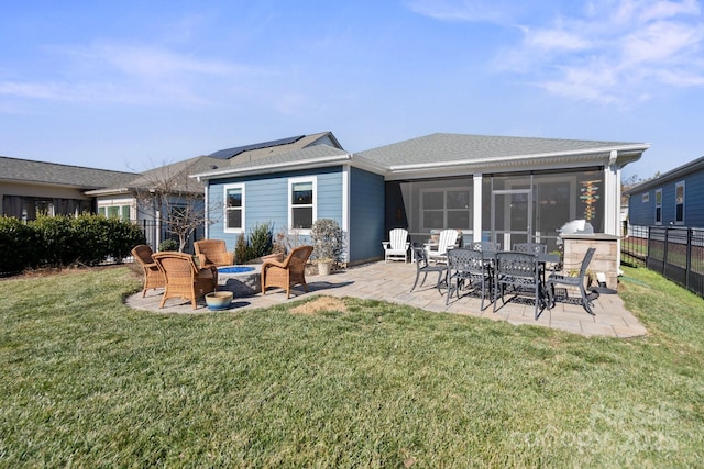 rear view of house featuring a lawn, a patio area, and a sunroom