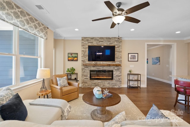 living room featuring ceiling fan, dark hardwood / wood-style floors, crown molding, and a fireplace