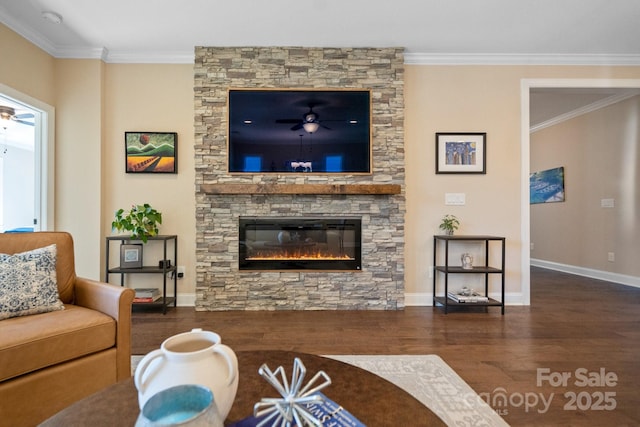 living room with ceiling fan, a stone fireplace, dark hardwood / wood-style flooring, and crown molding