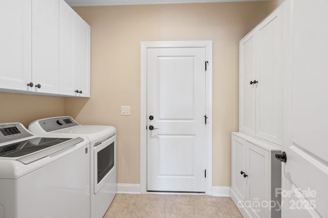 washroom featuring cabinets, light tile patterned floors, and washing machine and clothes dryer