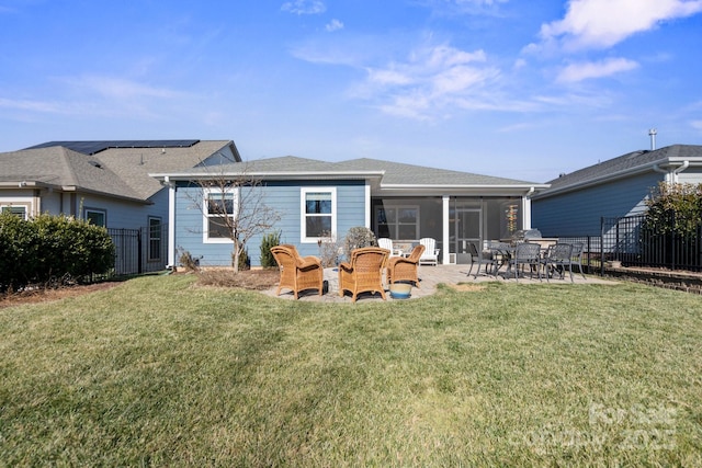 rear view of property with a sunroom, a lawn, and a patio