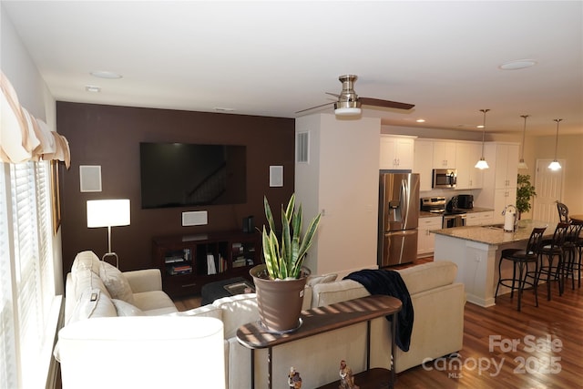 living room with sink, ceiling fan, and dark hardwood / wood-style floors