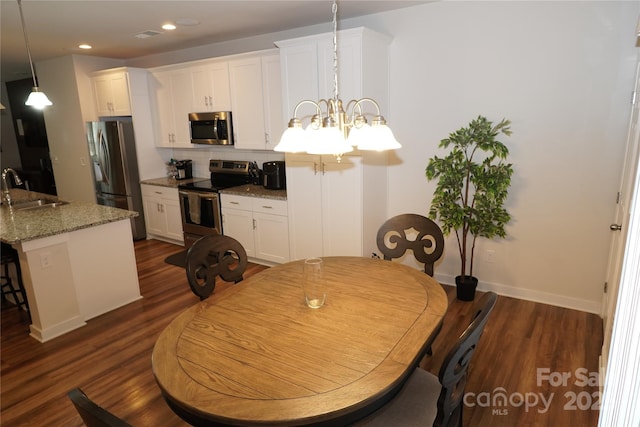 dining space featuring sink, a chandelier, and dark hardwood / wood-style floors
