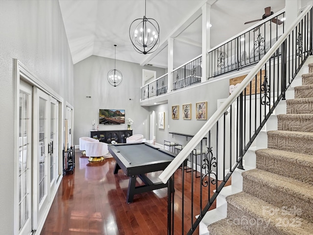 interior space with billiards, wood-type flooring, high vaulted ceiling, french doors, and ceiling fan with notable chandelier