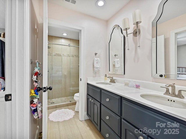 bathroom featuring toilet, vanity, an enclosed shower, and tile patterned flooring