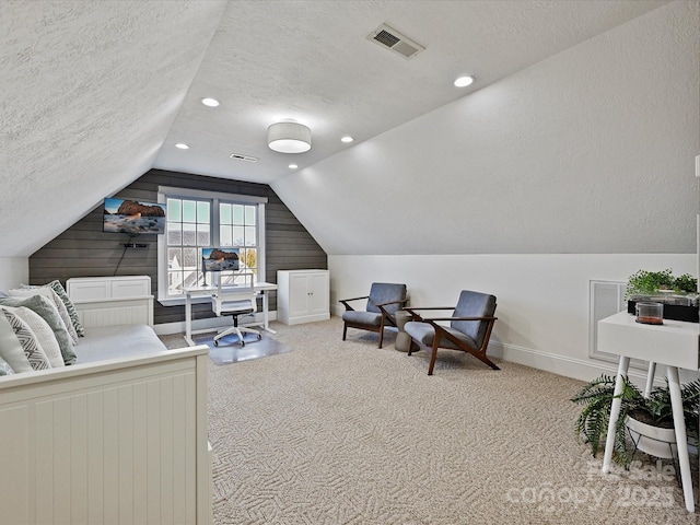 carpeted bedroom featuring vaulted ceiling and a textured ceiling