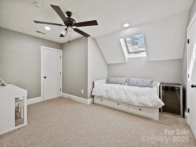 unfurnished bedroom with ceiling fan, light colored carpet, and lofted ceiling with skylight