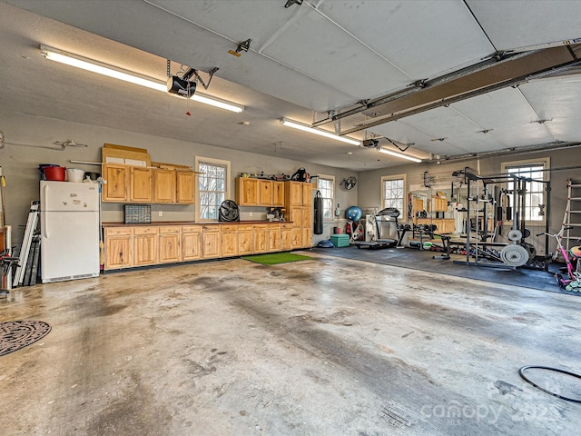 garage featuring a garage door opener and white fridge