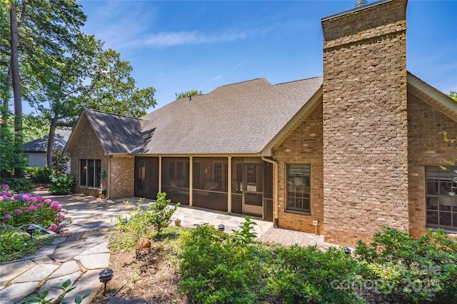 rear view of house with a patio area and a sunroom